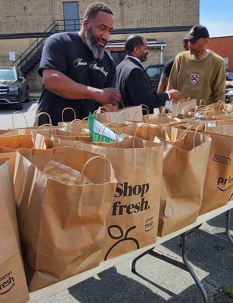 Families receiving fresh groceries at a Saturday giveaway